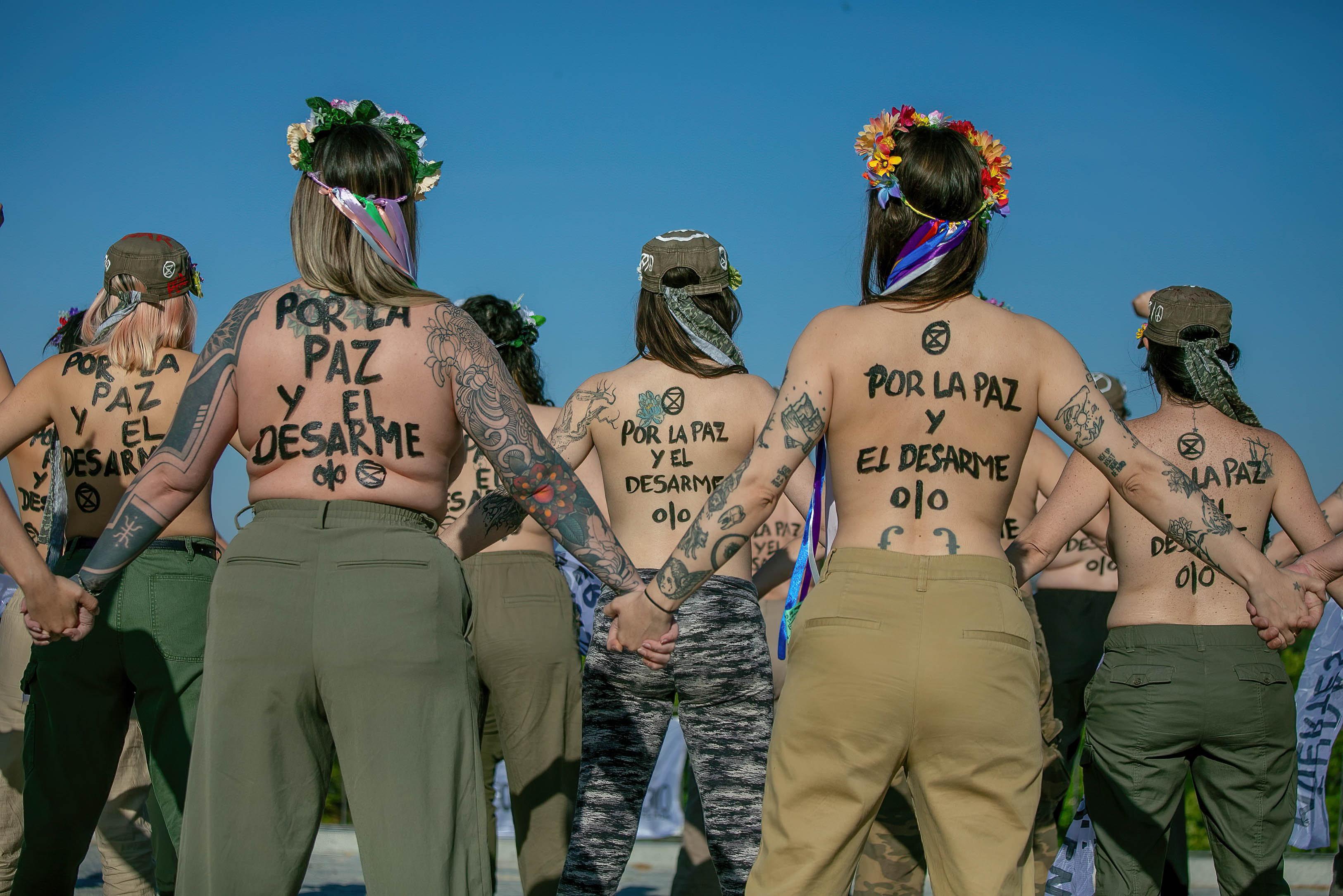 Activistas de Femen y Extinction Rebellion, con el torso desnudo y pintadas en sus cuerpos, participan en una acción