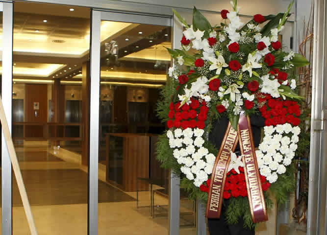 Una corona de flores enviada por los trabajadores de Viajes Marsans llega a la sede de la CEOE en Madrid durante la reunión de su Comité Ejecutivo.