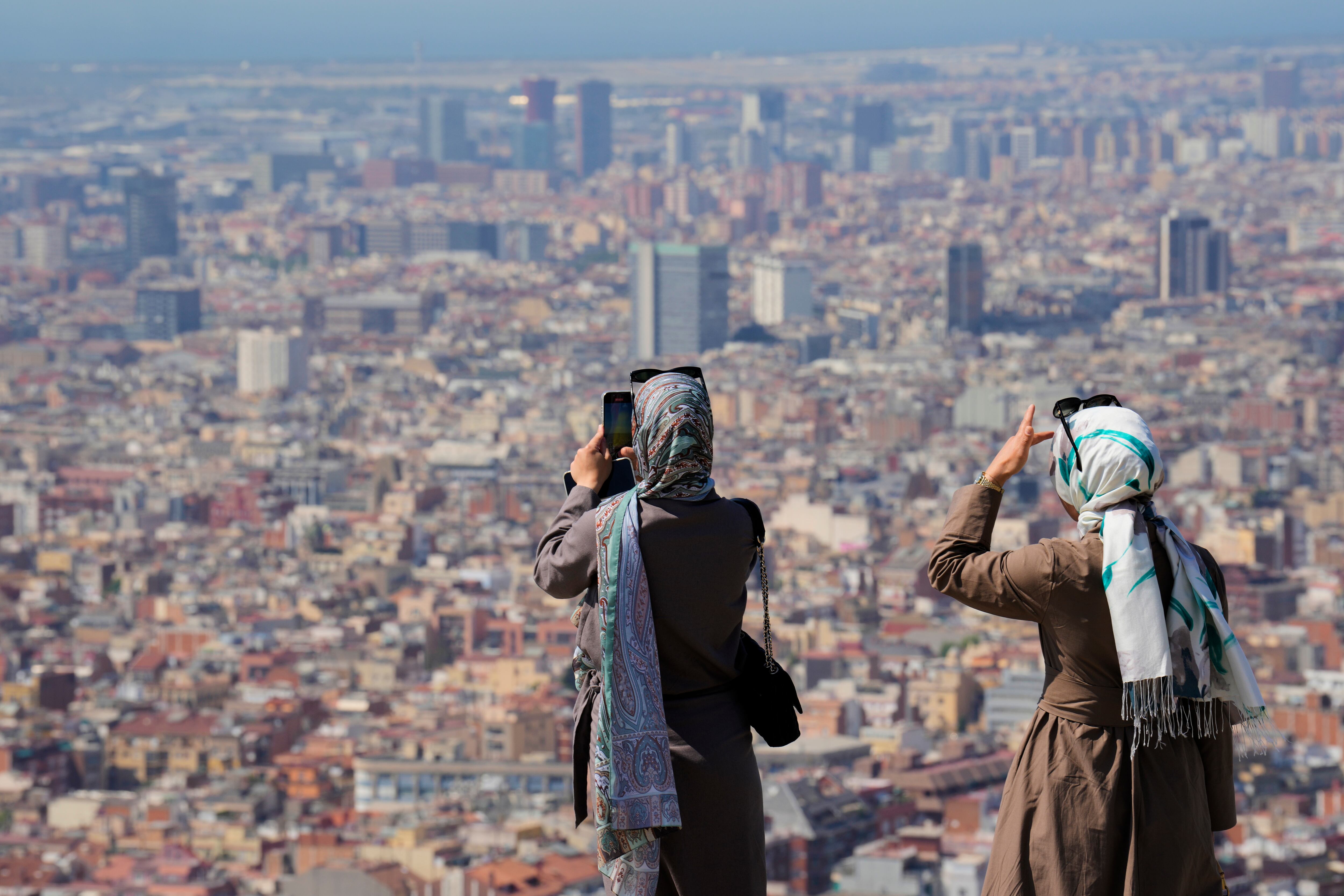 Turistas en el Turó de la Rovira de Barcelona este lunes cuando Cataluña vive el tercer día de la primera ola de calor de 2025.