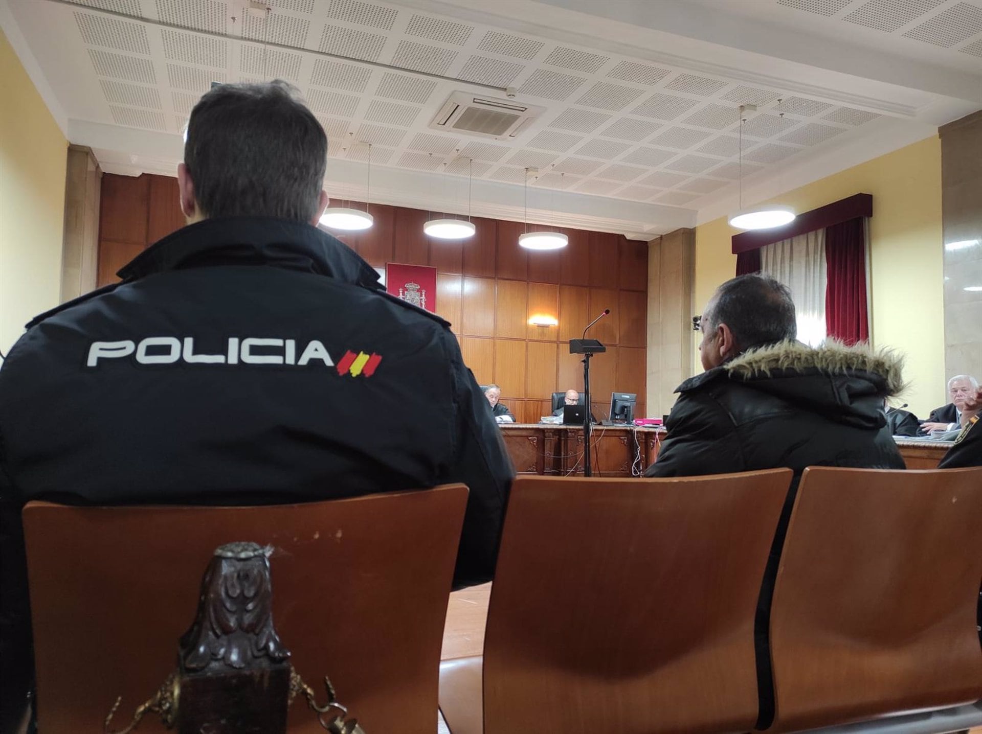 El acusado durante el juicio custodiado por agentes de policía.