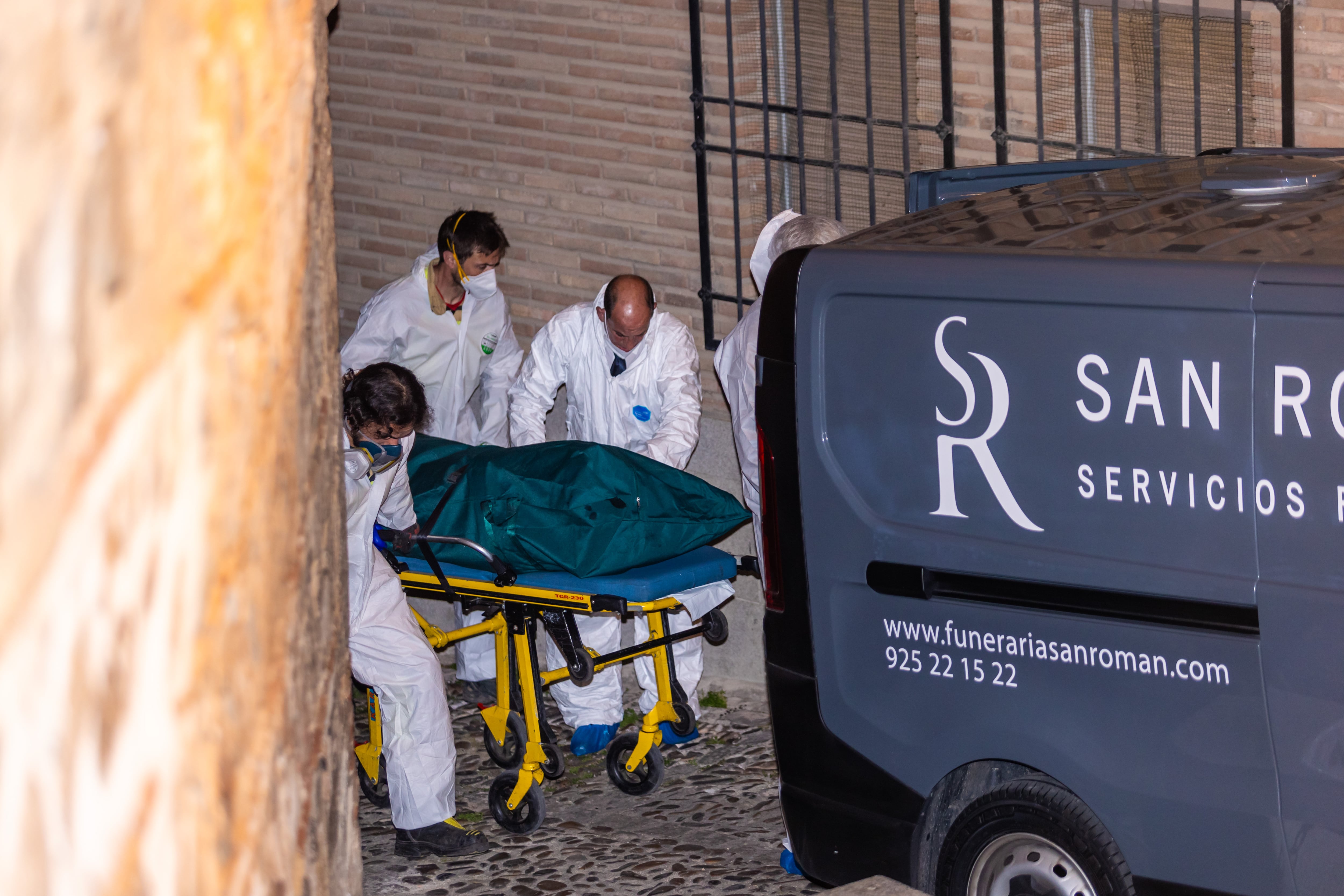 Miembros de los servicios funerarios trasportan uno de los cuatro cadáveres encontrados en la calle Santa Leocadia de Toledo, localizados en una vivienda de la capital.