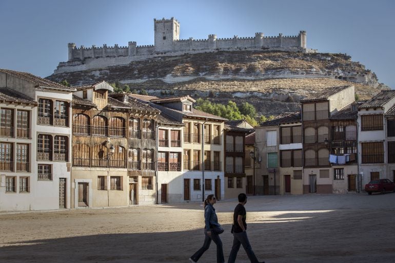 Una pareja transita por la Plaza del Coso con el castillo al fondo