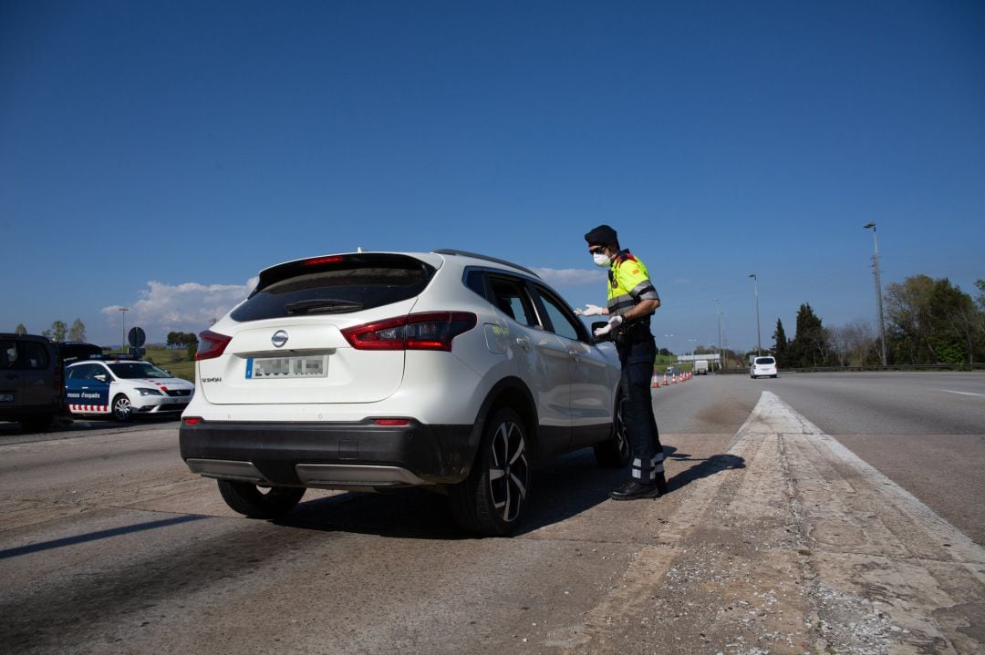 Un agente de los Mossos d&#039;Esquadra protegido con una mascarilla en un control en el peaje de La Roca del Vallès