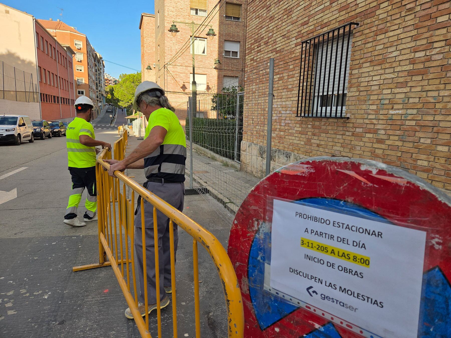 Dos operarios instalando las valles en la calle Jaume Roig para iniciar las obras