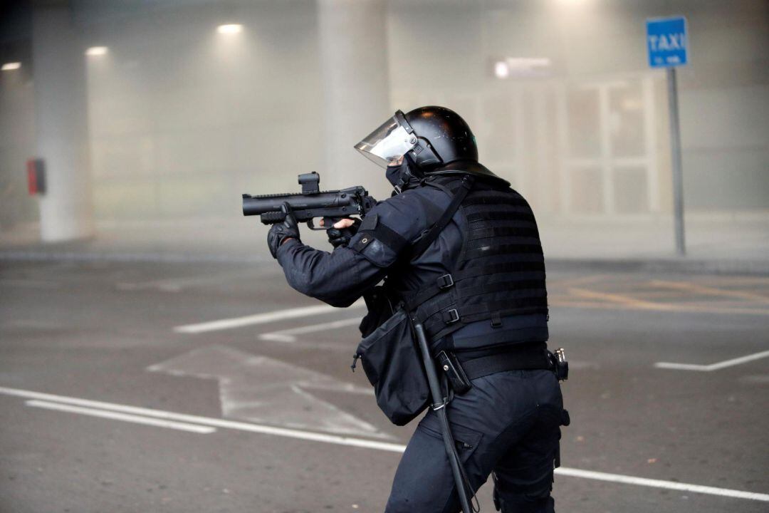 Agente durante las cargas contra manifestantes en el aeropuerto del Prat