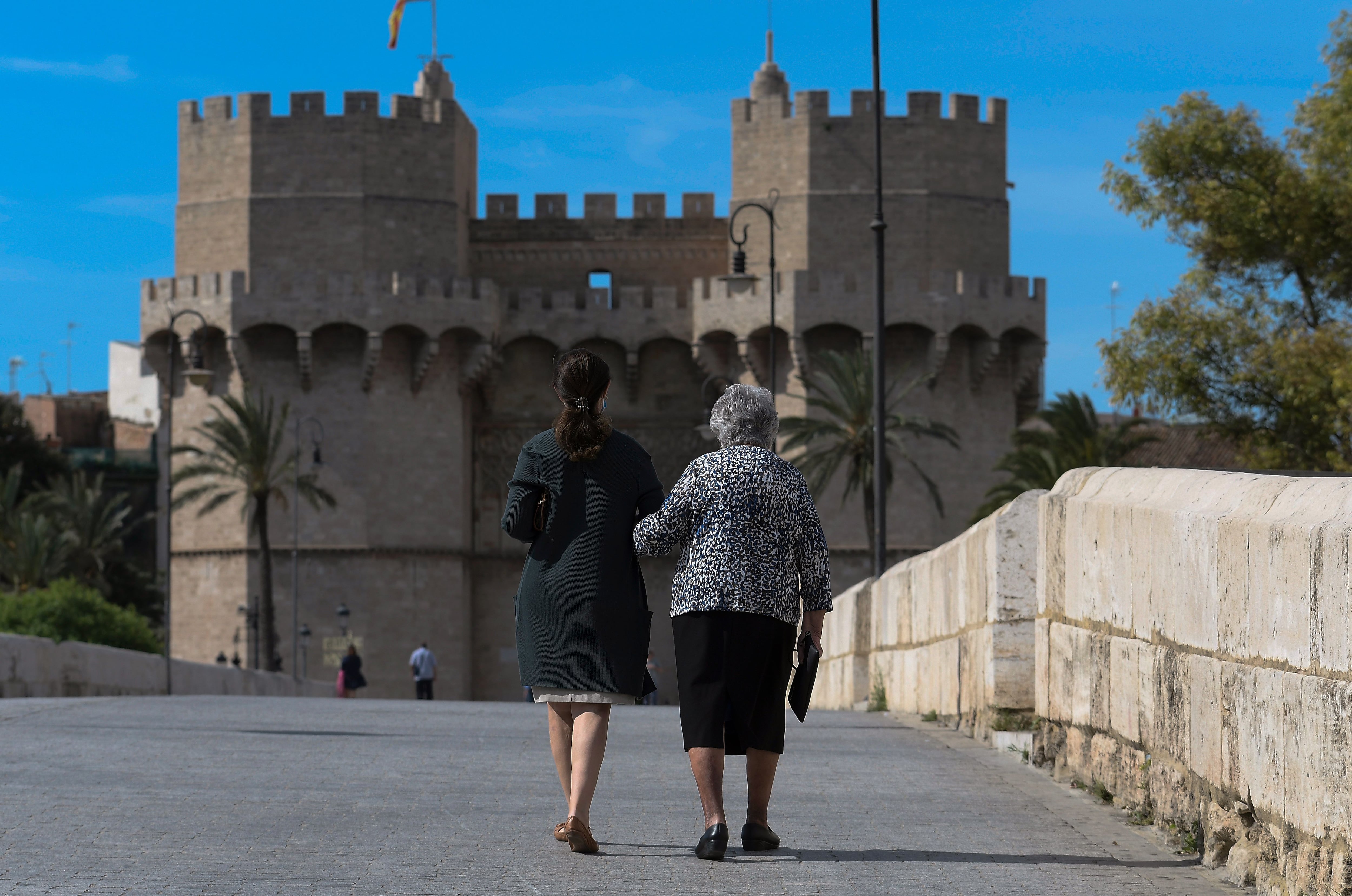 Mujeres cruzando el puente de Serranos de València