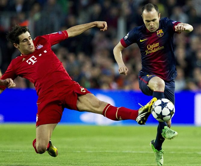 El centrocampista del F.C. Barcelona Andrés Iniesta (d) avanza con el balón ante el centrocampista del Bayern Múnich Javi Martínez, durante el partido correspondiente a la vuelta de las semifinales de la Liga de Campeones