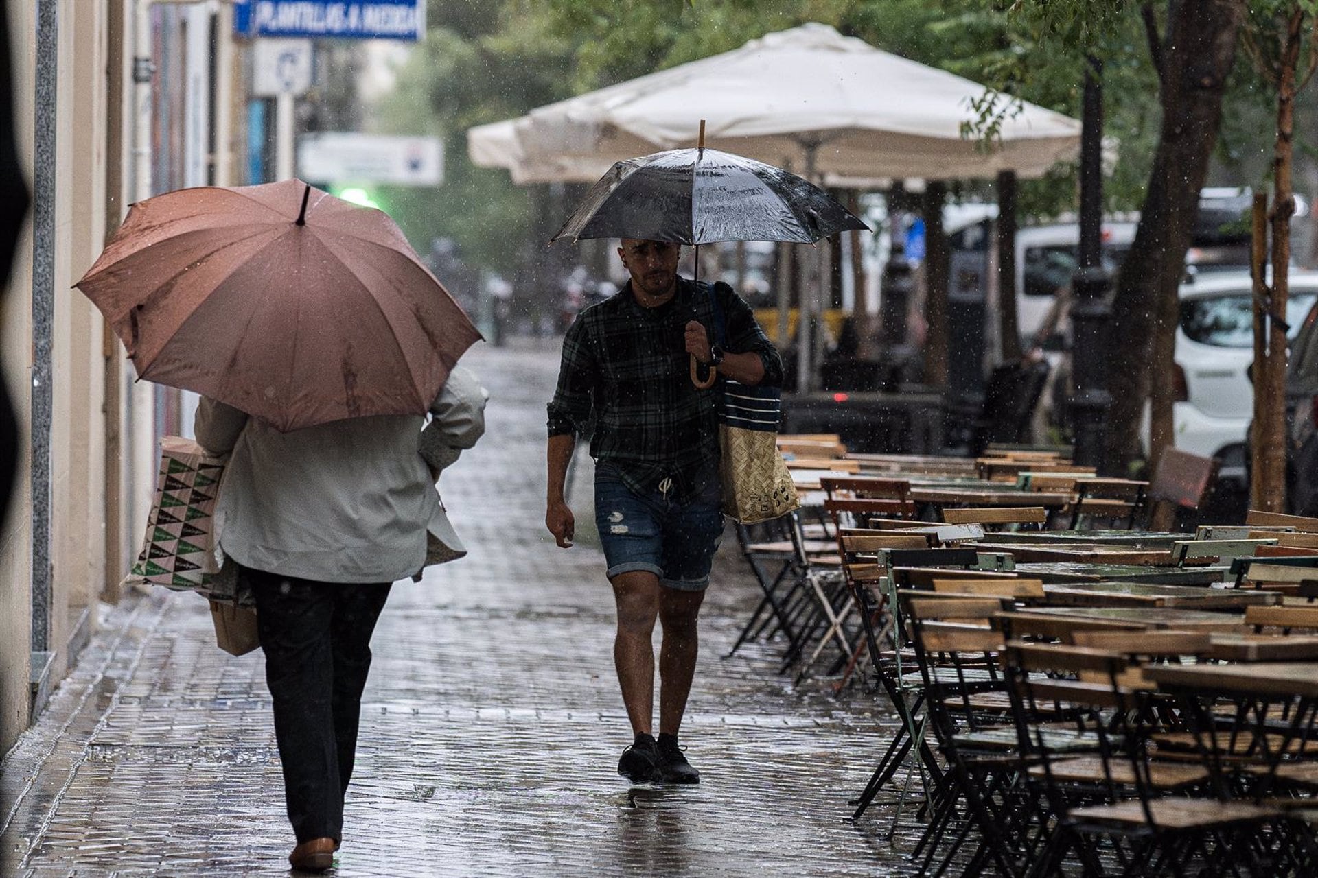 Varias personas se resguardan de la lluvia con paraguas, a 3 de septiembre de 2023,