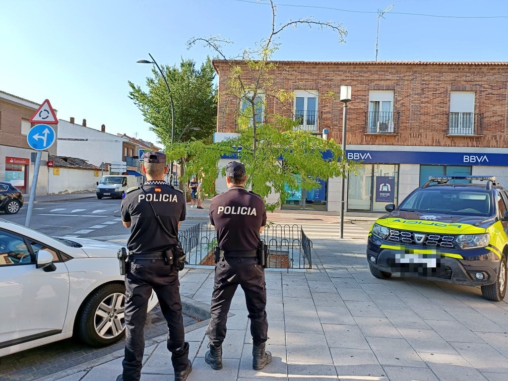 Dos agentes de la Policía Local delante de un banco