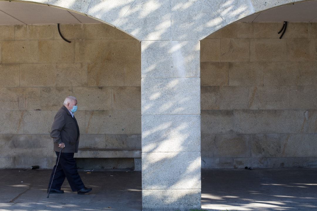 Un anciano caminando por la calle con mascarilla, en una imagen de archivo