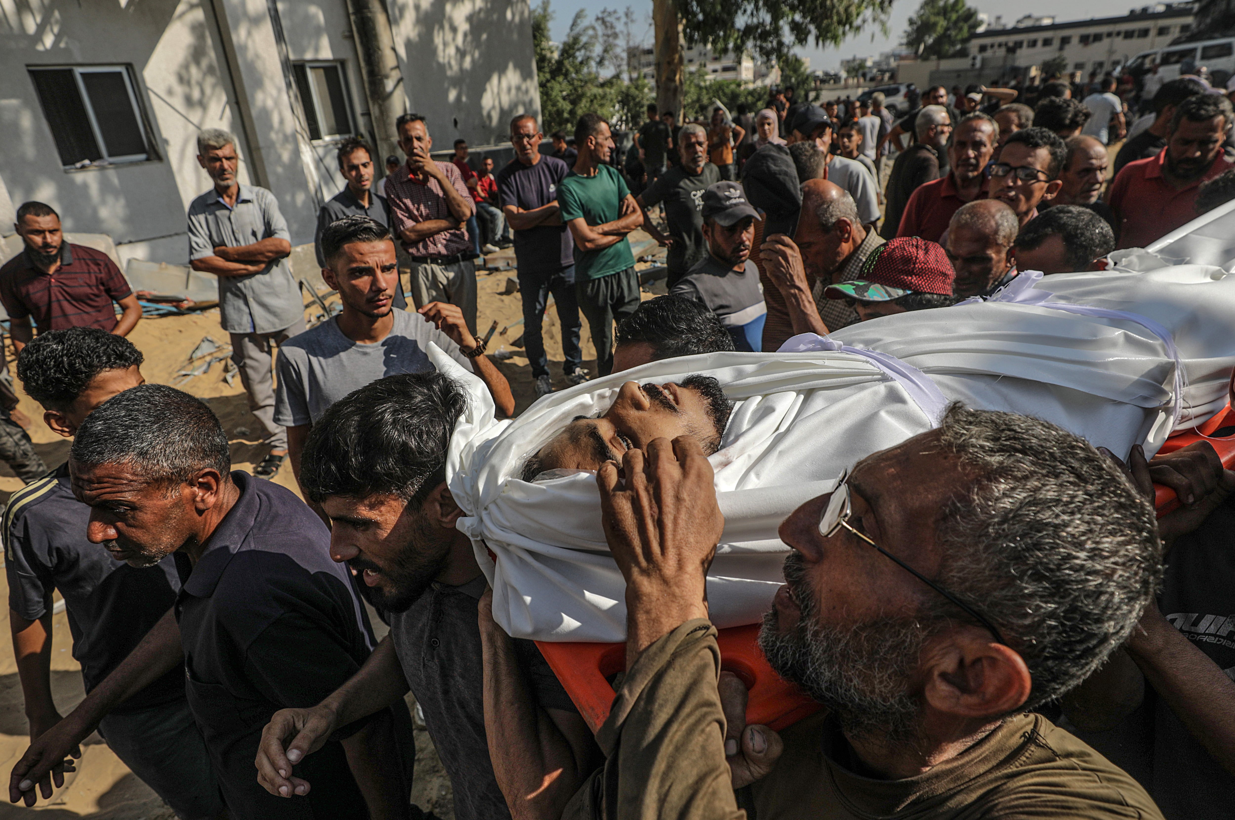 Inmediaciones del hospital Al Shifa (Gaza) donde un grupo de palestinos transporta un cuerpo. EFE/EPA/MOHAMMED SABER