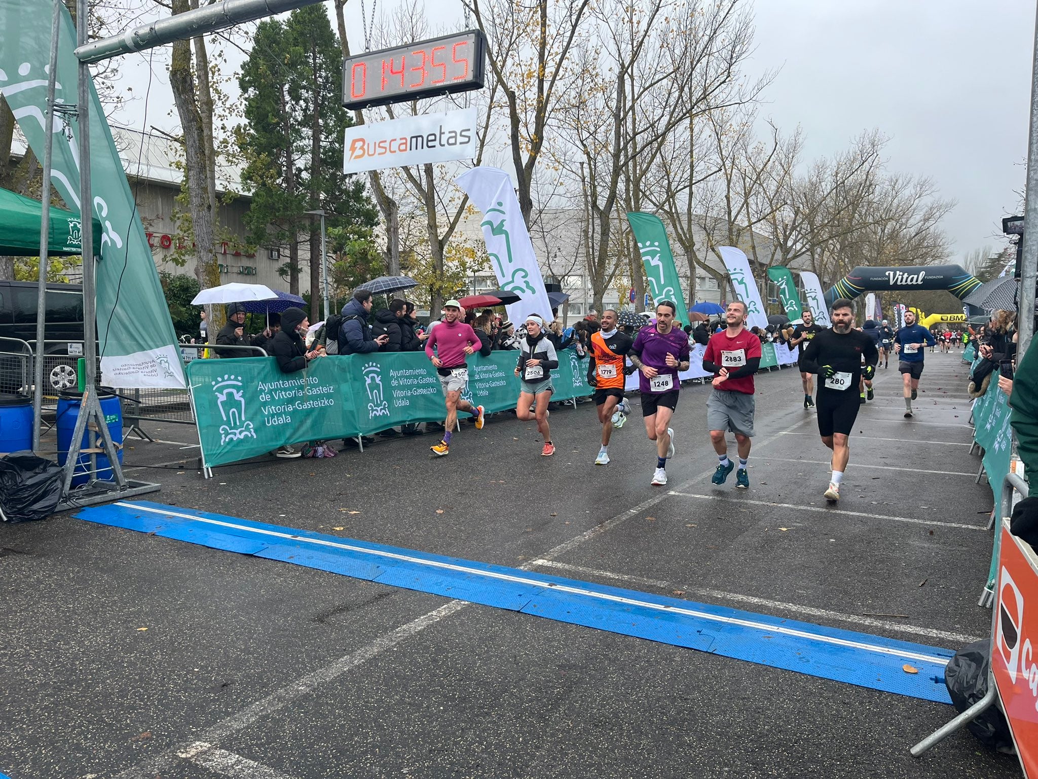 Un grupo de corredores llegando a la meta en Mendizorroza