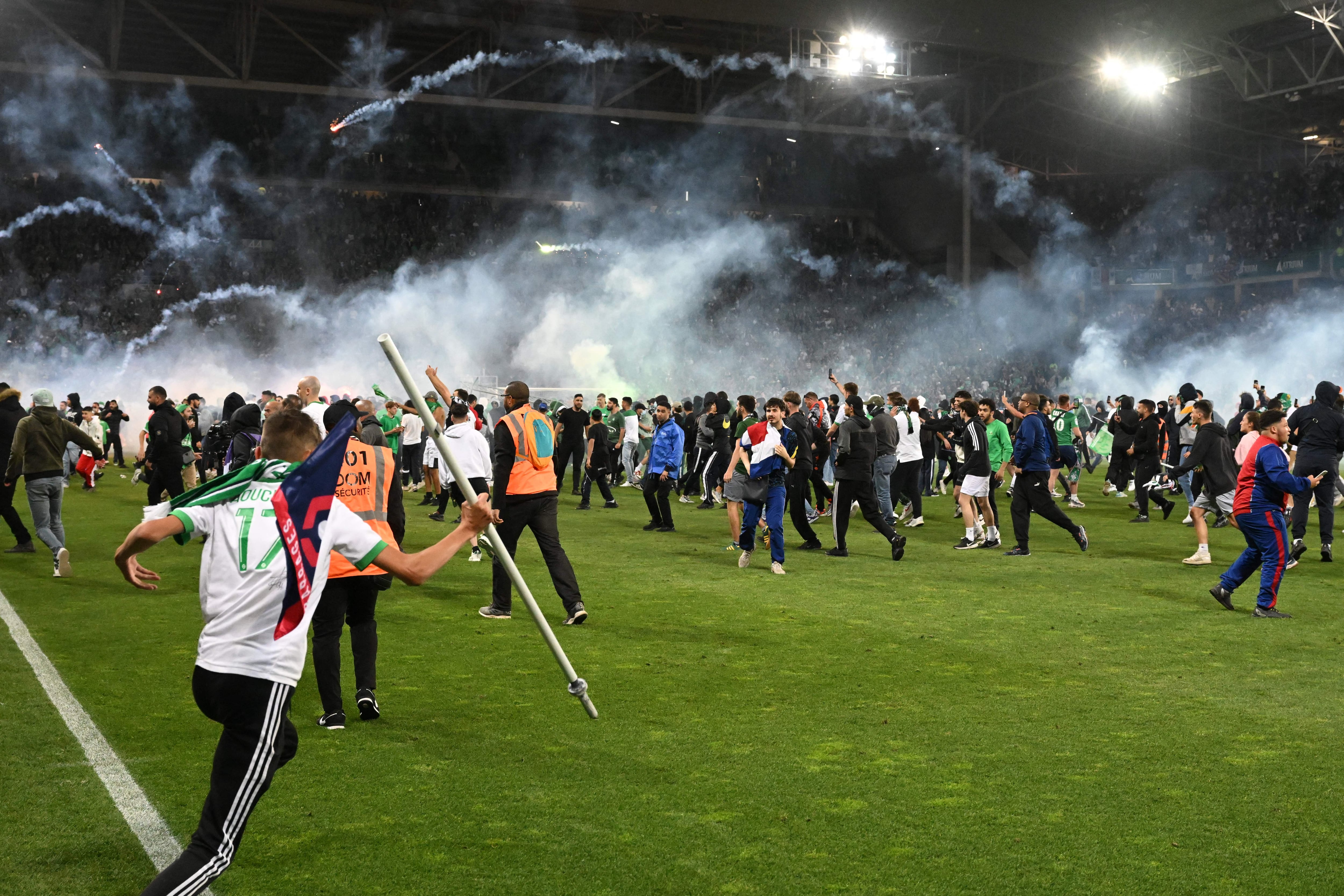 Los aficionados del Saint-Etienne saltando al césped tras el descenso de su equipo