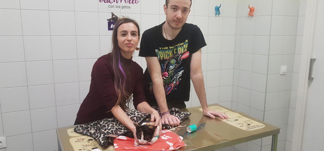 Dos de los voluntarios de Dejando Huella con una de las gatas atendidas