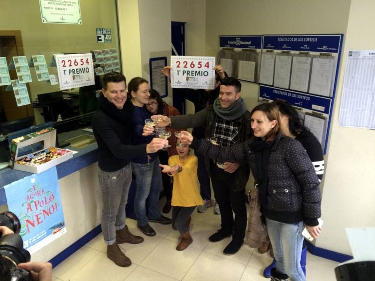 El primer premio del sorteo extraordinario de la lotería de El Niño ha estado muy repartido. En la foto,un grupo de personas en la administración de loteria de Pontecesures donde se ha vendido el primer premio