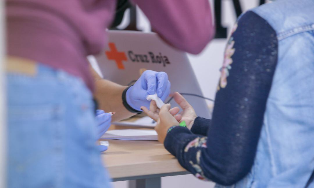 Un profesional sanitario realiza un test de coronavirus a una mujer.