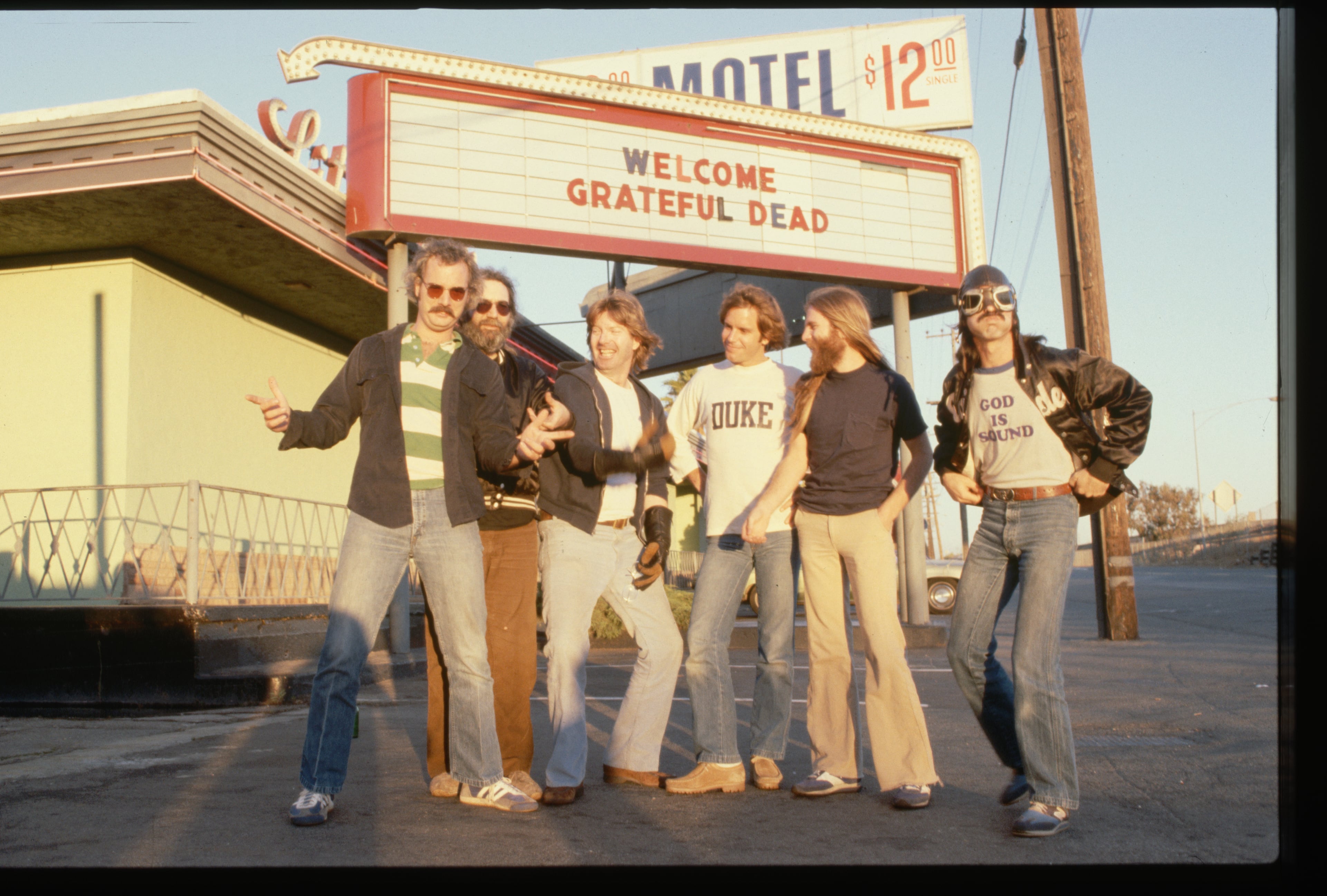 Los chicos de Grateful Dead posan junto a una valla que anuncia su concierto en 1970