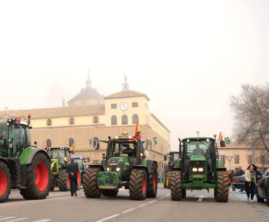 Una fila de tractores avanza por las calles de Toledo, durante la manifestación de agricultores y ganaderos