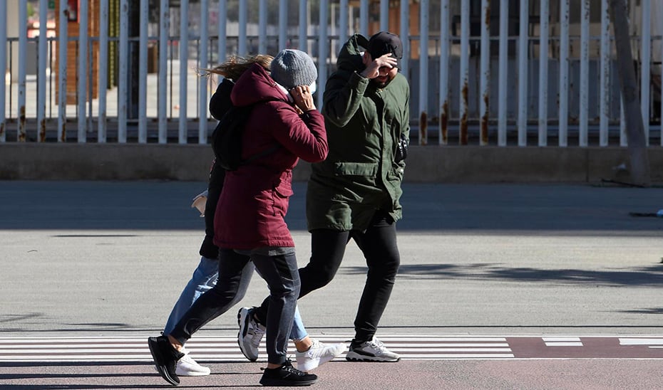 GRAFAND6732. ALMERÍA, 17/01/2023.- Varias personas intentan mantener el equilibrio en una calle de Almería, durante el temporal de viento que azota la provincia y por la que la AEMET ha declarado la alerta naranja por rachas de hasta 80 km/h. EFE Carlos Barba
