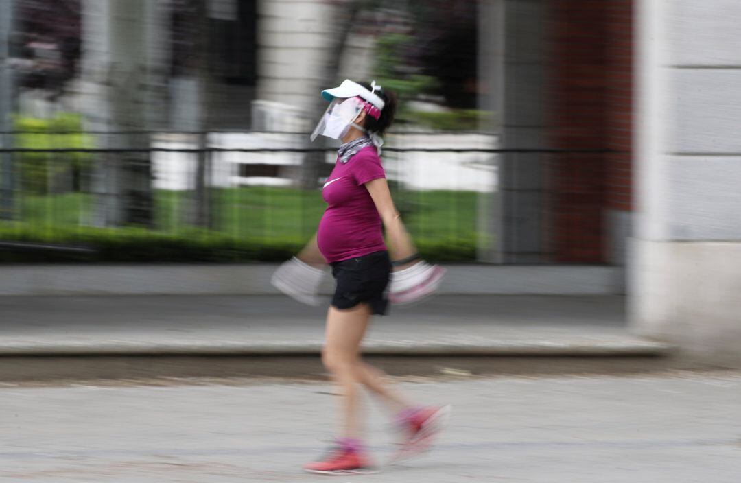 Una mujer embarazada y con visera de protección