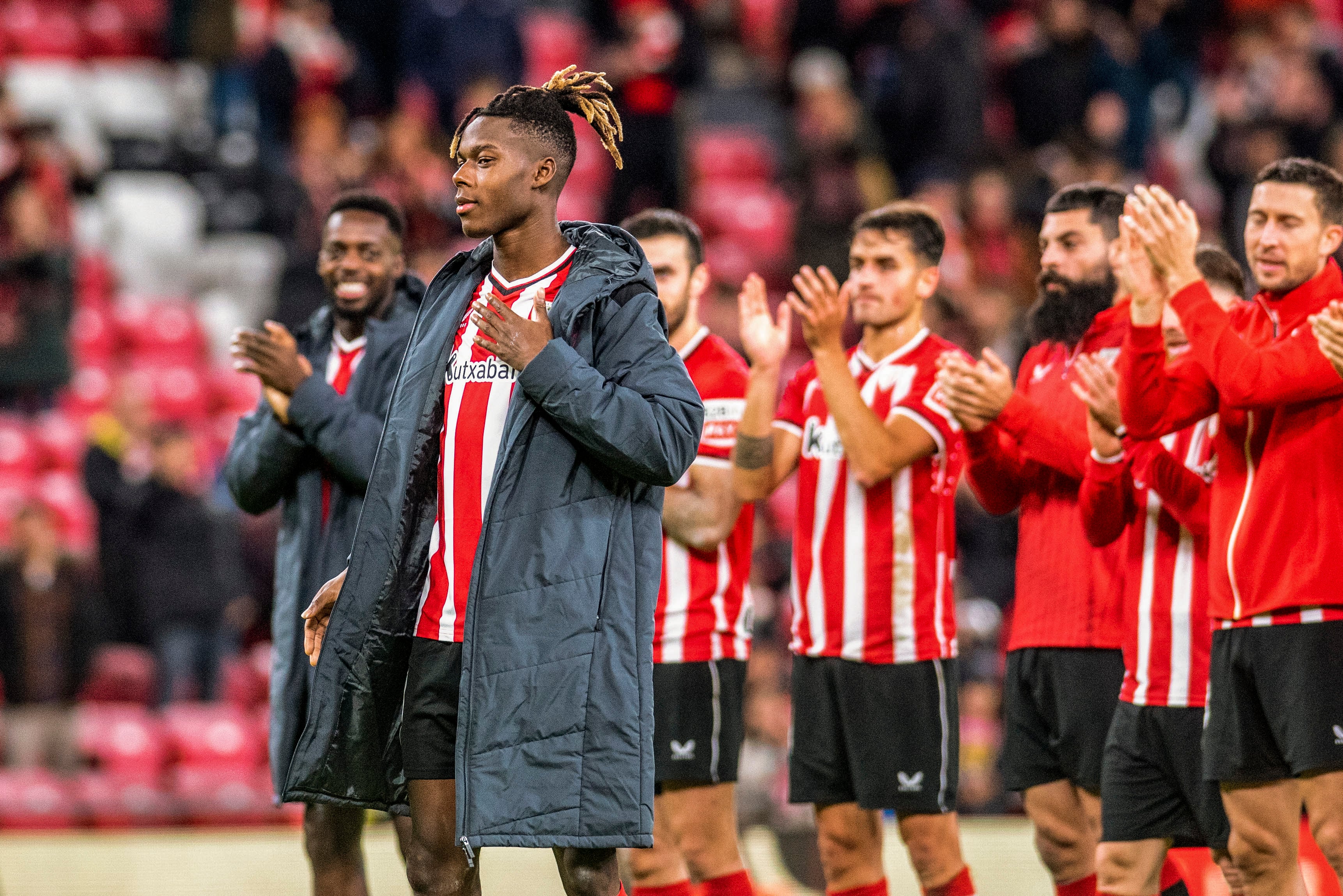 BILBAO, 02/12/2023.- El delantero del Athletic Club de Bilbao Nico Williams (2i), que anunció ayer su renovación con el club, saluda a la afición ante la mirada de su hermano mayor Iñaki (i), al terminar el partido de Liga de Primera División ante el Rayo Vallecano que han disputado este sábado en el estadio de San Mamés, en Bilbao. EFE/Javier Zorrilla
