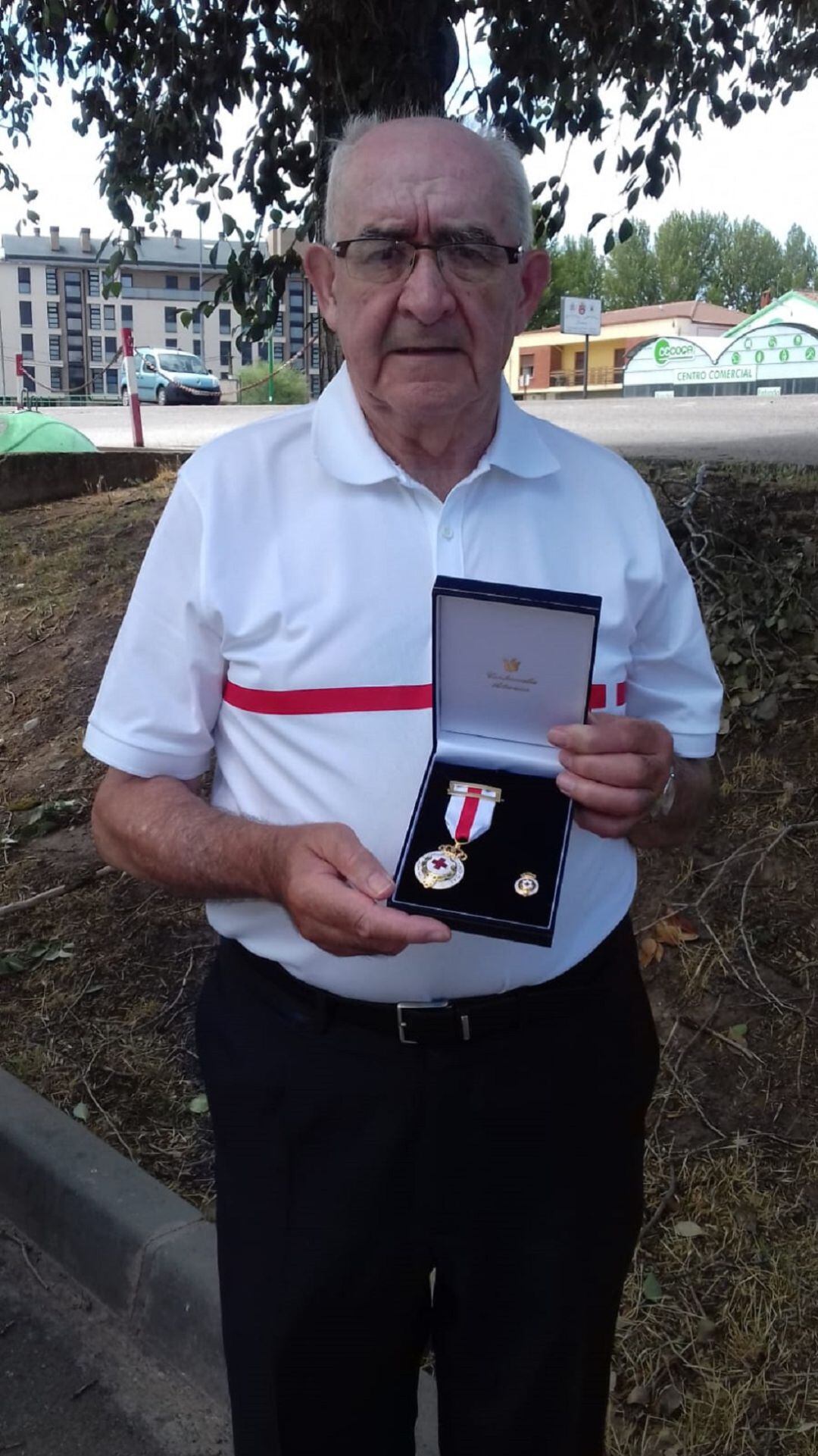 Pedro de Benito sostiene una de las merecidas distinciones por su trabajo en Cruz Roja