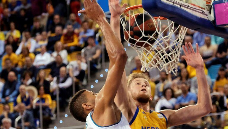 El pivot estadounidense de pasaporte armenio del Herbalife Gran Canaria Luke Fischer intenta taponar al pivot caboverdiano del Real Madrid Edy Tavares en el tercer partido del play off de semifinales de la Liga Endesa que se disputa esta noche en el Gran Canaria Arena .