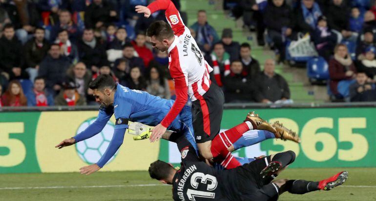 El delantero del Getafe, Jorge Molina (i) cae ante los jugadores del Athletic de Bilbao, el defensa francés Aymeric Laporte (c) y el guardameta Iago Herrerín, jugada en la que el colegiado ha concedido penalti a favor del equipo azulón, durante el encuent