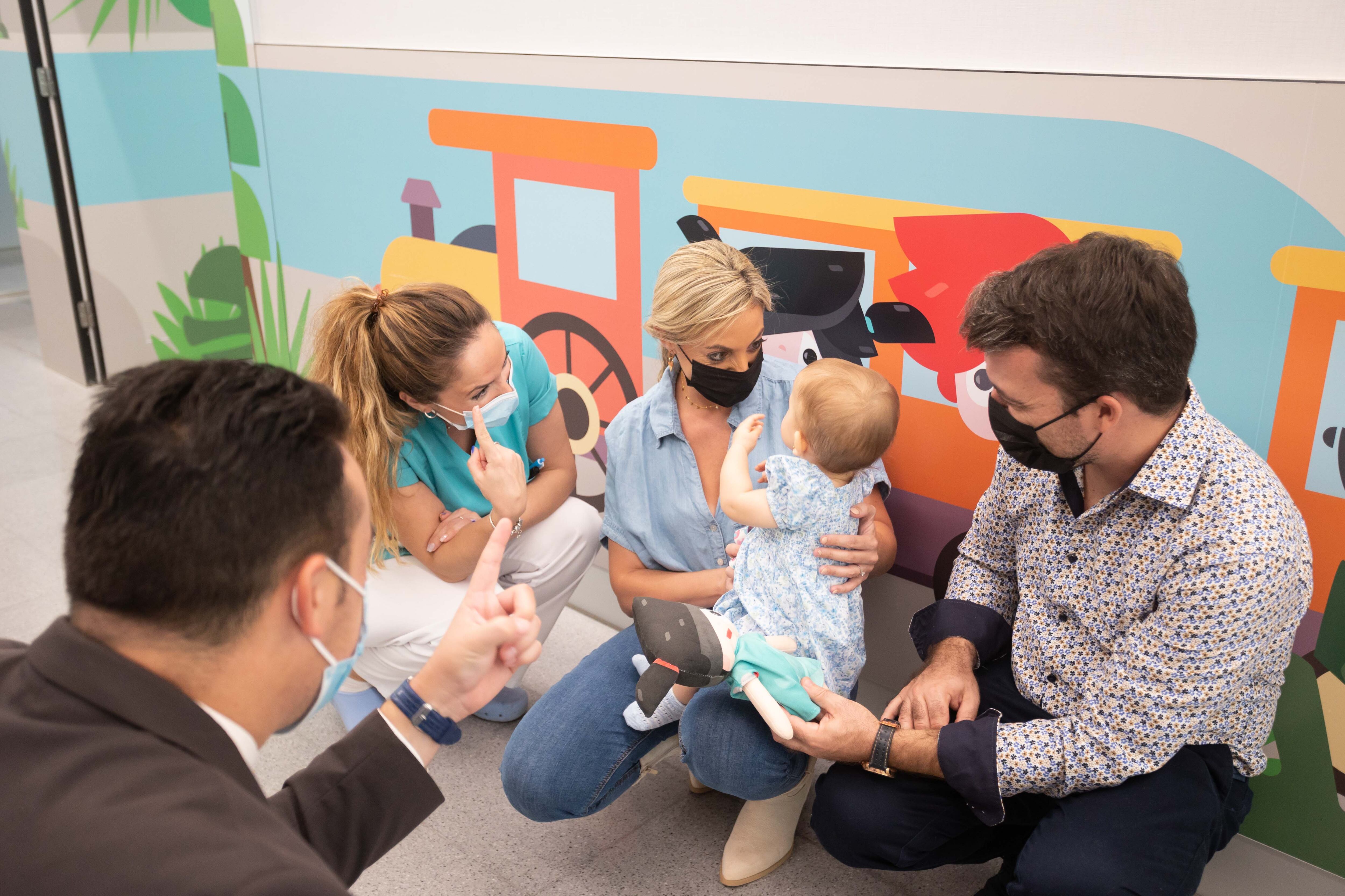 En la imagen la pequeña Carmen junto a sus padres recibiendo un regalo del personal de pediatría del hospital.