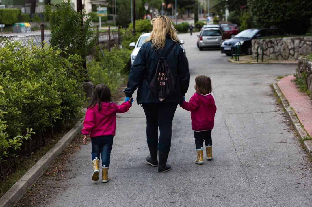 Una madre pasea con sus hijas en Madrid.