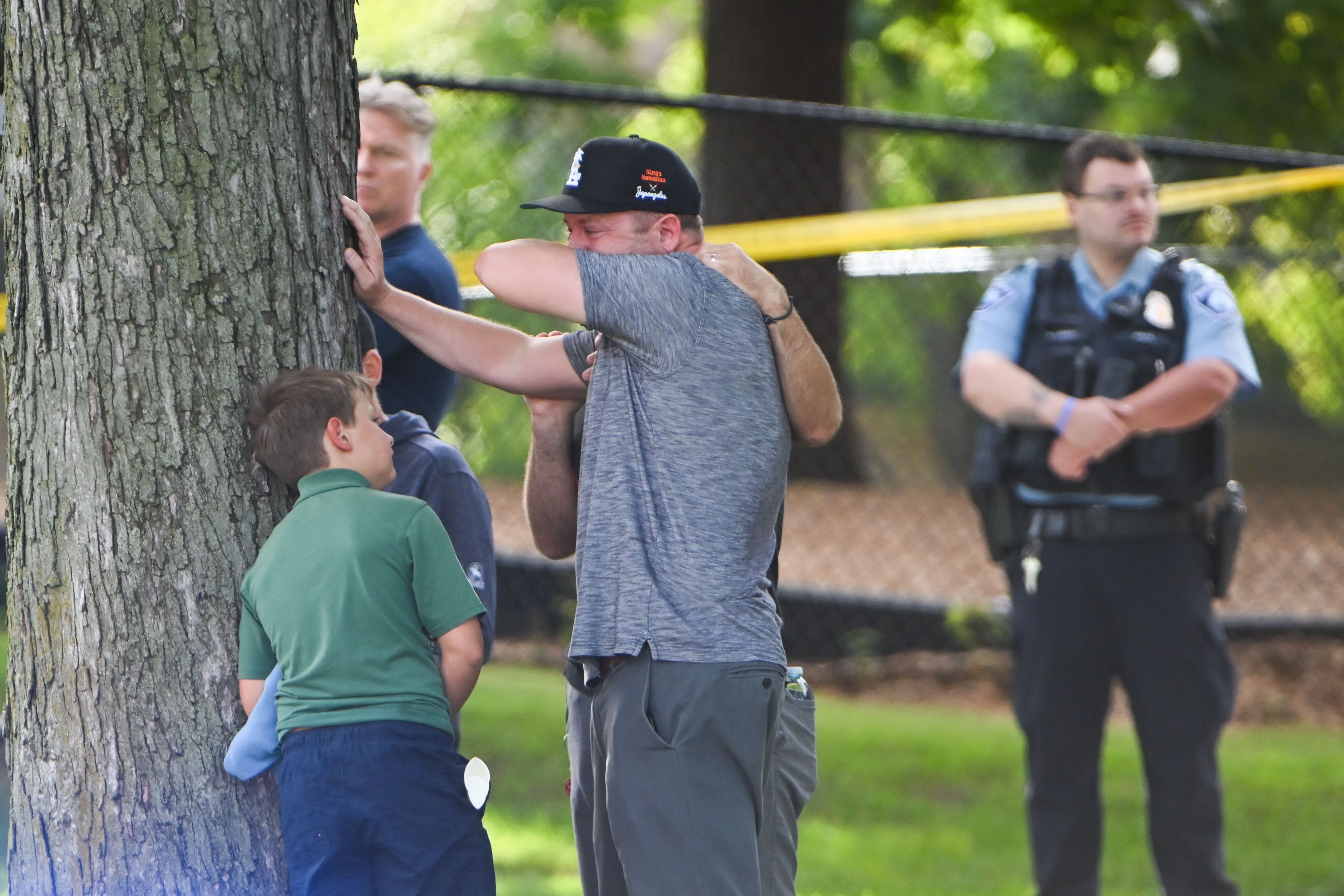 Un adulto y un niño salen de la escuela tras un tiroteo en la Escuela Católica Annunciation en Minneapolis (EEUU)