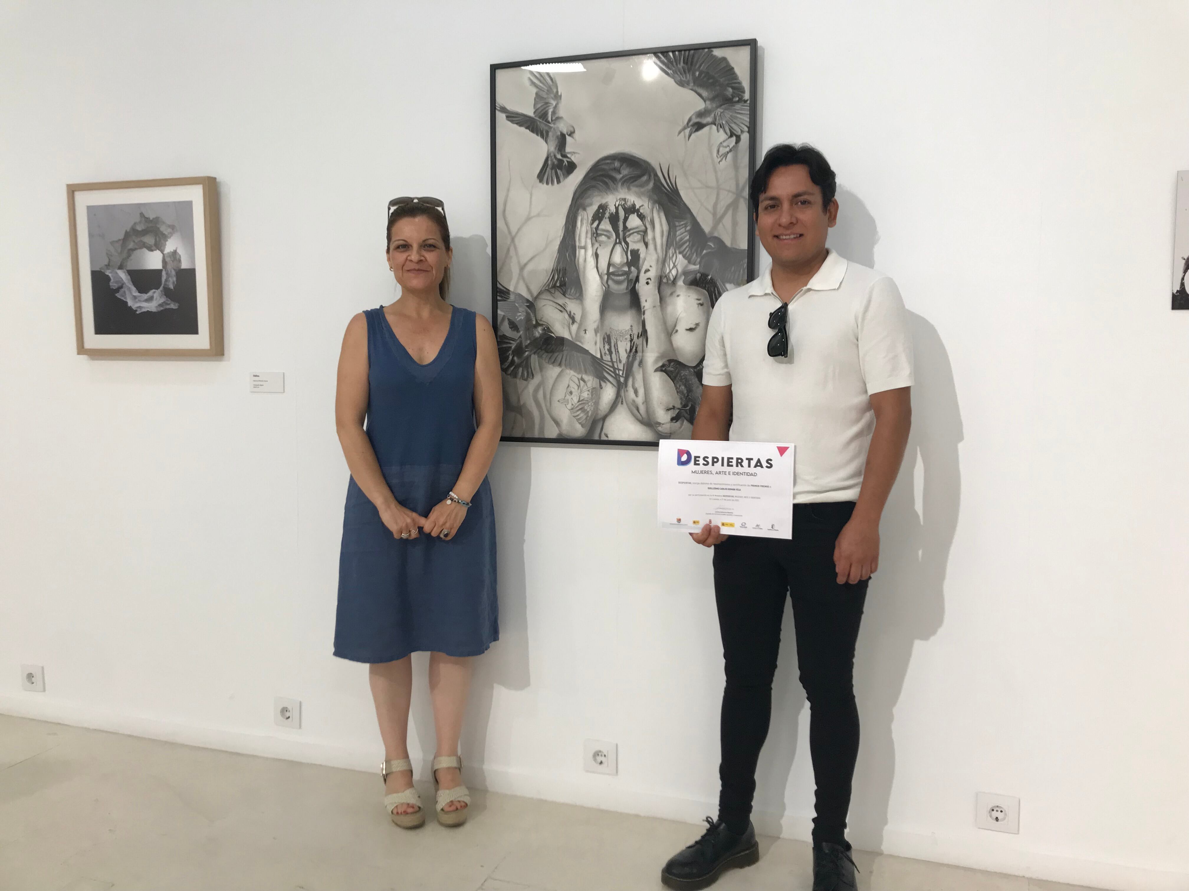 Guillermo Román, ganador del primer premio del III Certamen Despiertas, junto a su obra &#039;Los cuervos no cantan&#039; y la diputada de Servicios Sociales, Lorena Cantarero.