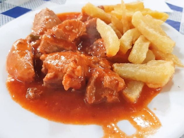 Guiso de carne con tomate y patatas fritas