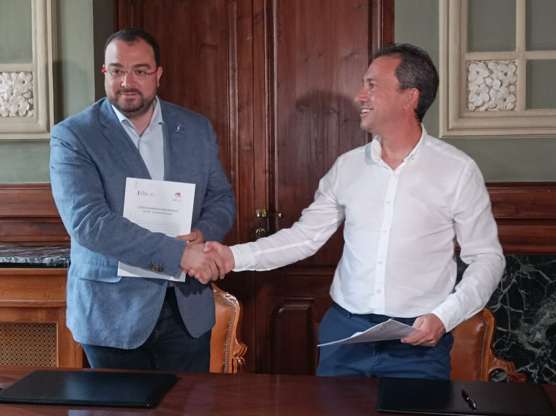 Apretón de manos de Adrián Barbón (PSOE) y Ovidio Zapico (IU) tras firmar el acuerdo de gobierno