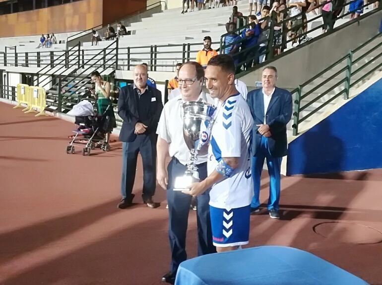 Momento de la entrega del trofeo tras el encuentro contra el CD Marino, en el estadio Antonio Domínguez de Los Cristianos (Arona) recogido por Suso Santana