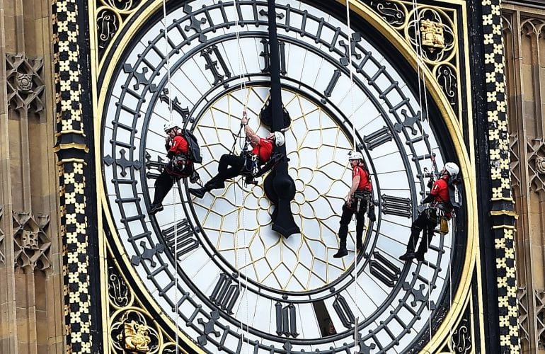 Varias personas descienden por la esfera del Big Ben.