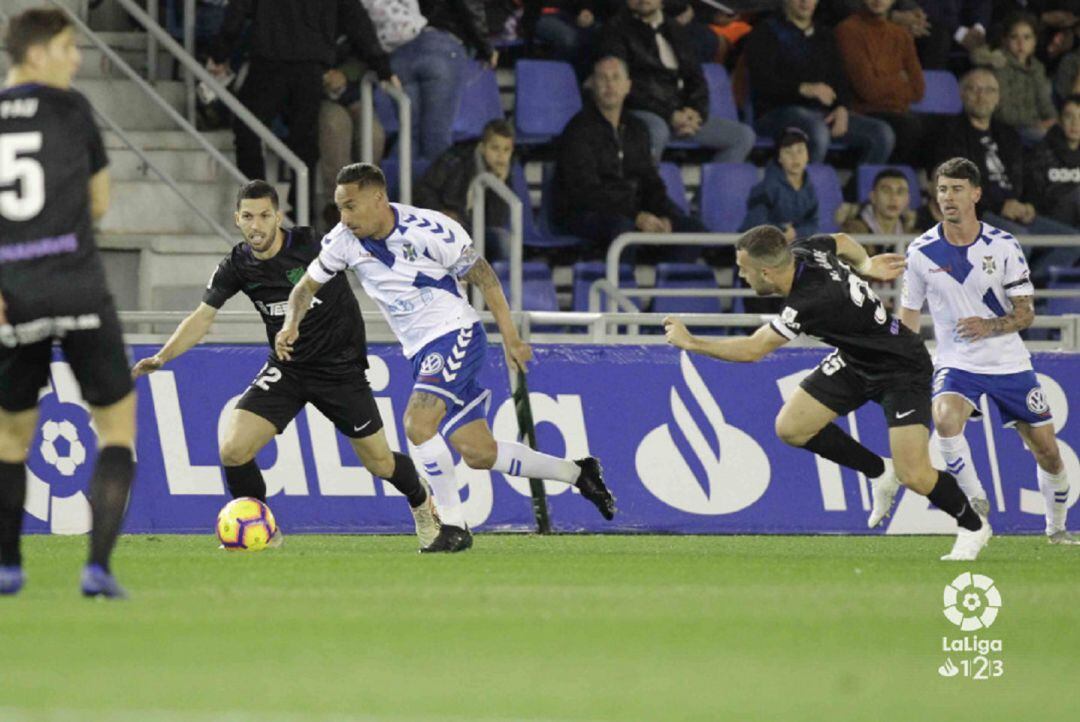 Suso trata de progresar con el balón controlado ante varios jugadores del Málaga