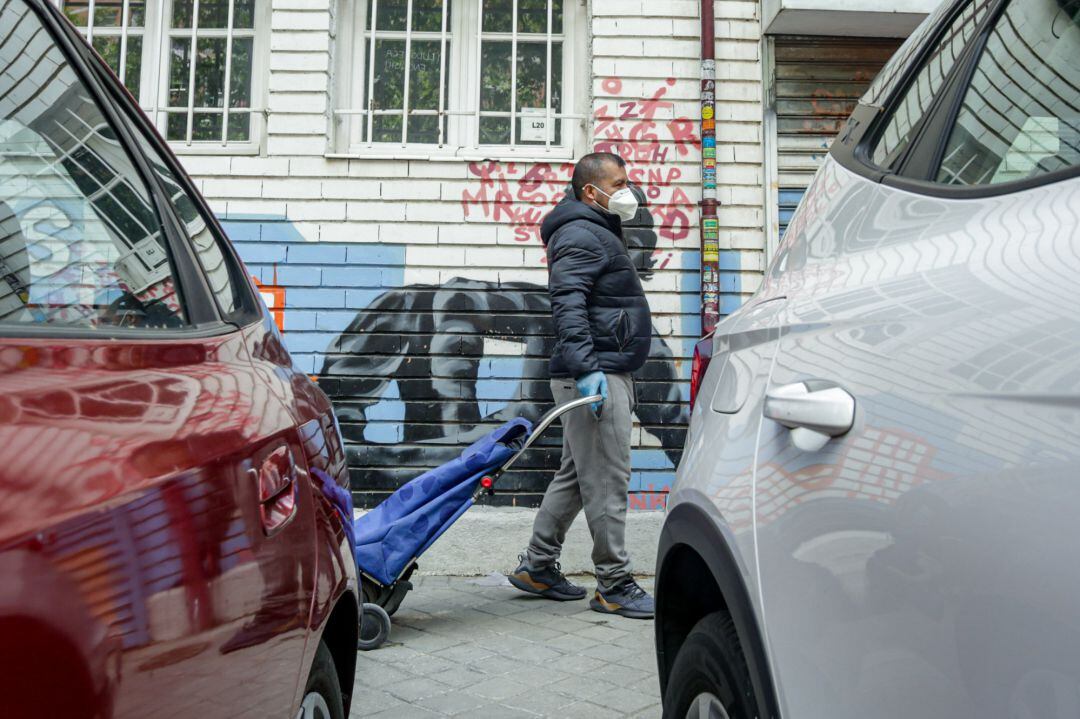 Vecinos realizan una cola para recoger bolsas de alimentos