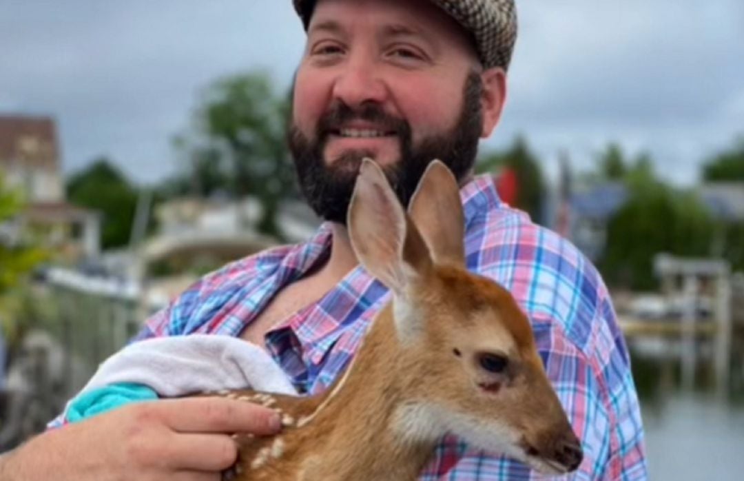 Chad junto con el pequeño cervatillo tras sacarlo del río.