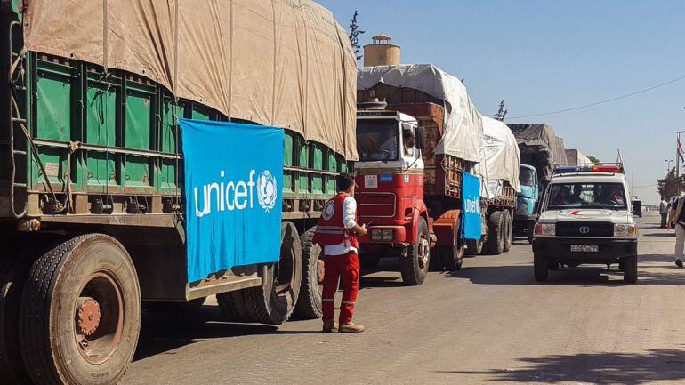 Fotografía cedida por la Media Luna Roja Siria que muestra un convoy de camiones antes de partir para entregar ayuda humanitaria en el área rural de Alepo (Siria).