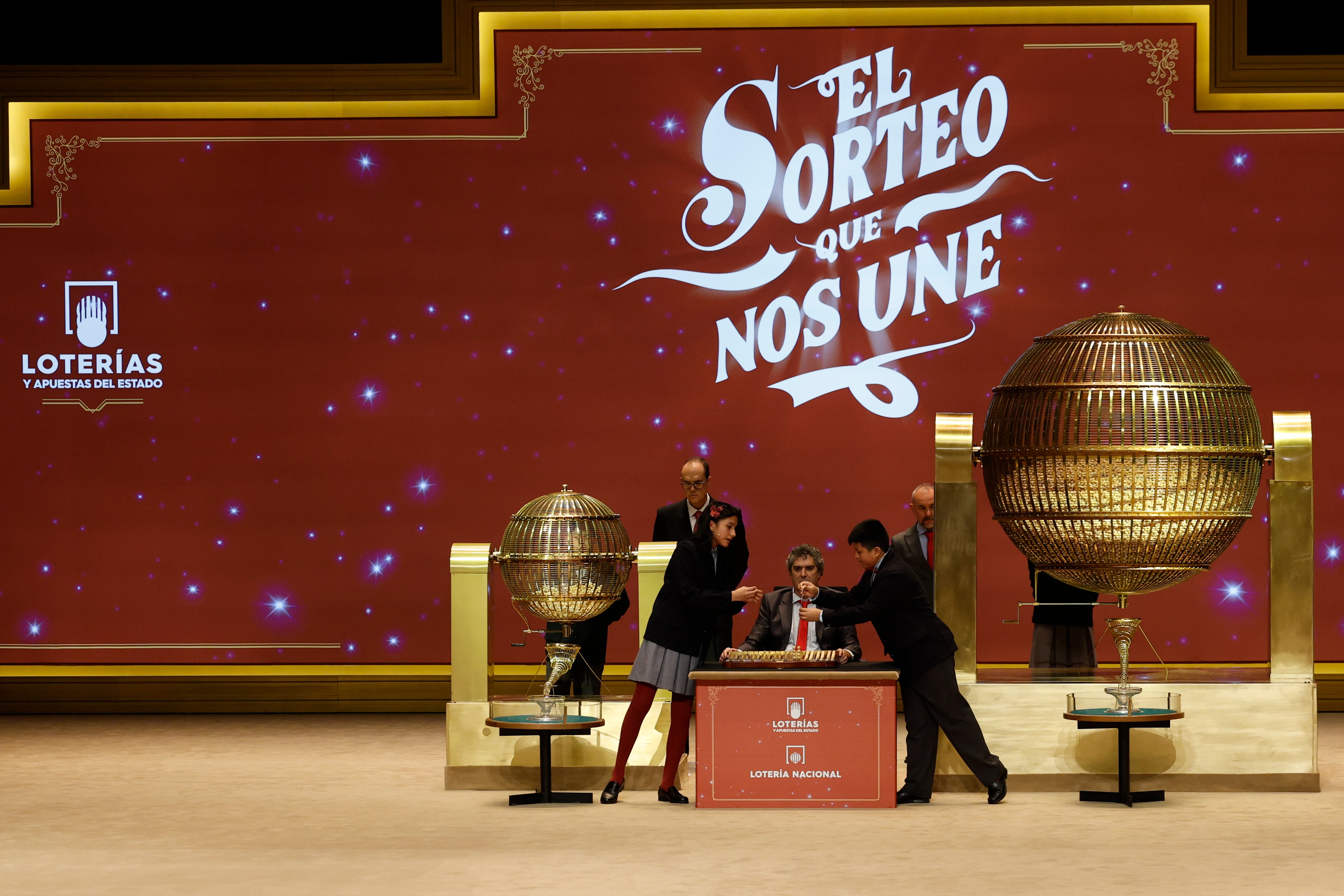 MADRID, 22/12/2025.- Aisha Solange (i) y Gorka Calderón (d), los niños de la Residencia San Ildefonso del Ayuntamiento de Madrid encargados de cantar premio y número, respectivamente, de la segunda tabla de del Sorteo Extraordinario de Navidad celebrado este lunes en el Teatro Real de Madrid. EFE/Chema Moya