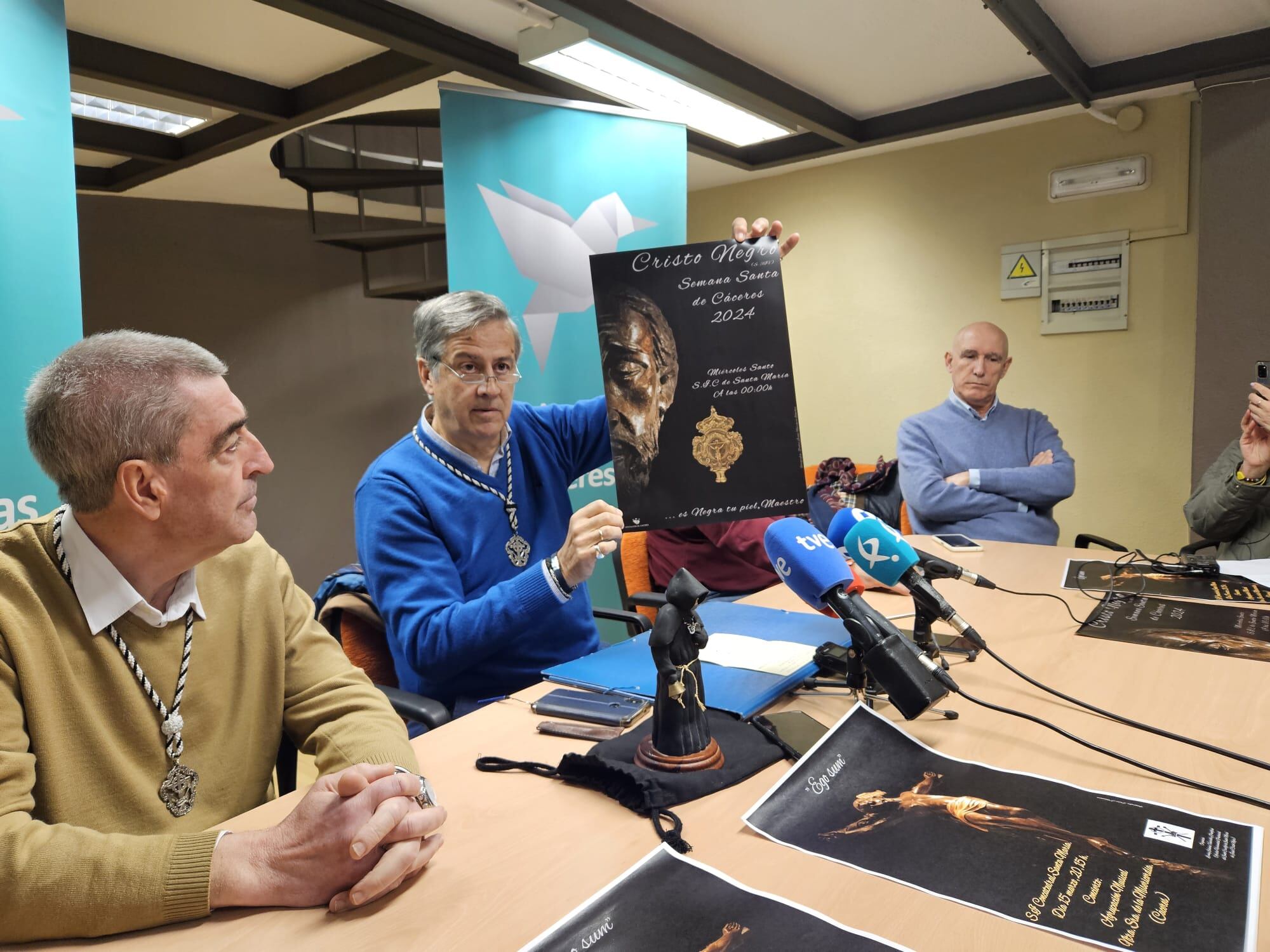 Miembros de la Cofradía del Cristo Negro presentan el cartel para la Semana Santa 2024.