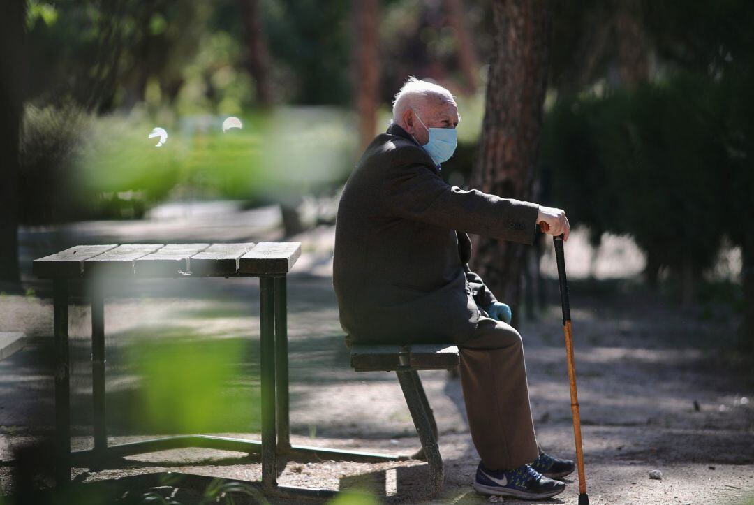 Un anciano con mascarilla descansa en el Parque Calero, en el distrito de Ciudad Lineal de la capital, uno de los que el Ayuntamiento de Madrid ha abierto y en los que se permite pasear y hacer ejercicio, en Madrid (España), a 8 de mayo de 20202.