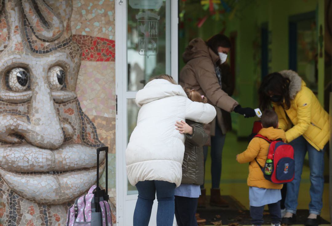 Una niña se despide a su llegada al primer día de clase presencial tras la Navidad.