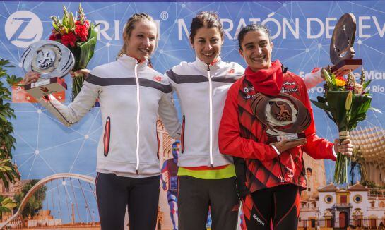 La atleta cántabra Paula González (c), que ha ganado la 32 edición del maratón de Sevilla con un tiempo de 2.31:18 que supone rebajar la mínima olímpica en su debut en la distancia y proclamarse campeona de España de la modalidad, posa en el podio acompañ