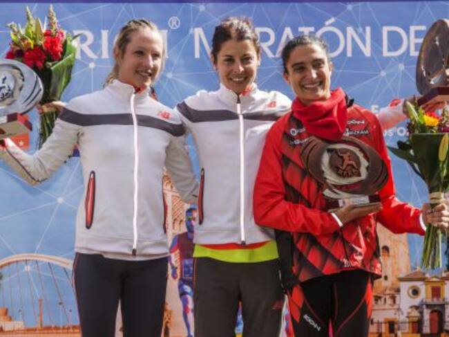 La atleta cántabra Paula González (c), que ha ganado la 32 edición del maratón de Sevilla con un tiempo de 2.31:18 que supone rebajar la mínima olímpica en su debut en la distancia y proclamarse campeona de España de la modalidad, posa en el podio acompañ