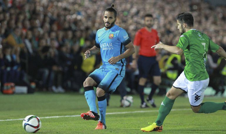 El defensa brasileño del F. C. Barcelona, Douglas Pereira, golpea el balón ante el delantero del Villanovense, Calatrava