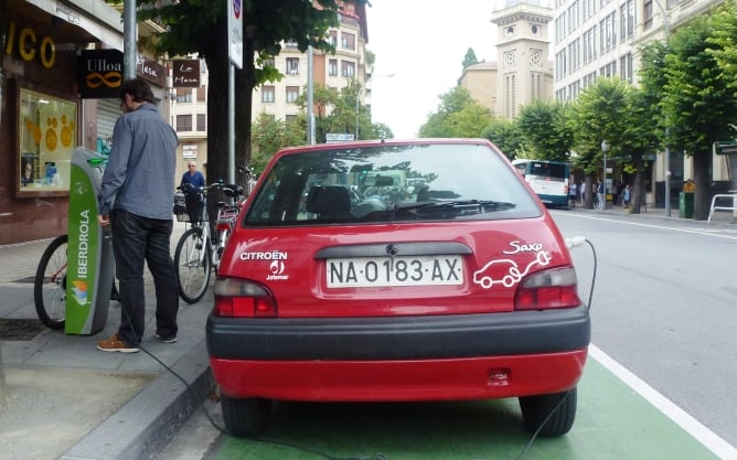 Un usuario carga la batería de su vehículo eléctrico en uno de los puntos de recarga en Pamplona.