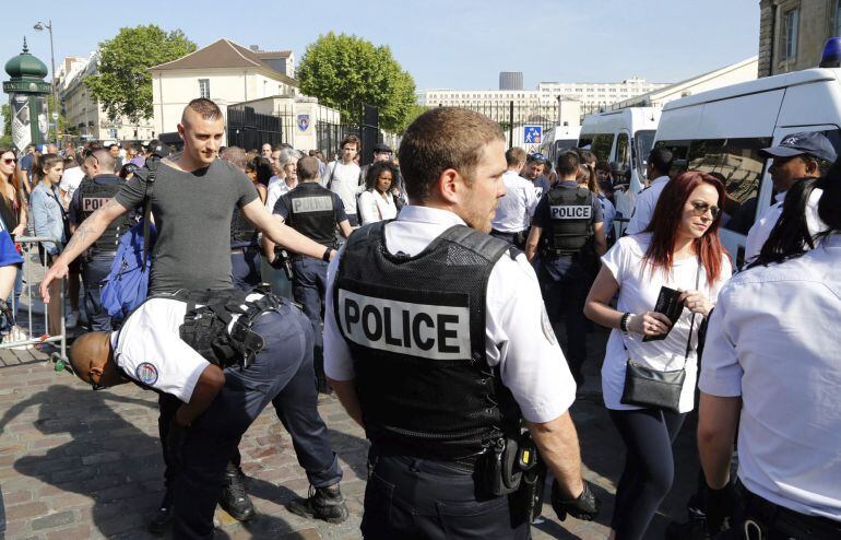 La policía francesa registra a varias personas junto a la zona de aficionados próxima a la torre Eiffel en París
