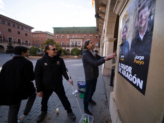 TERUEL, 23/01/2026.- Javier Carbó, numero uno de la lista de Teruel por Chunta Aragonesista, durante la tradicional tradicional pegada de carteles electorales de los partidos políticos, este viernes en la plaza San Juan de Teruel. EFE/Antonio García